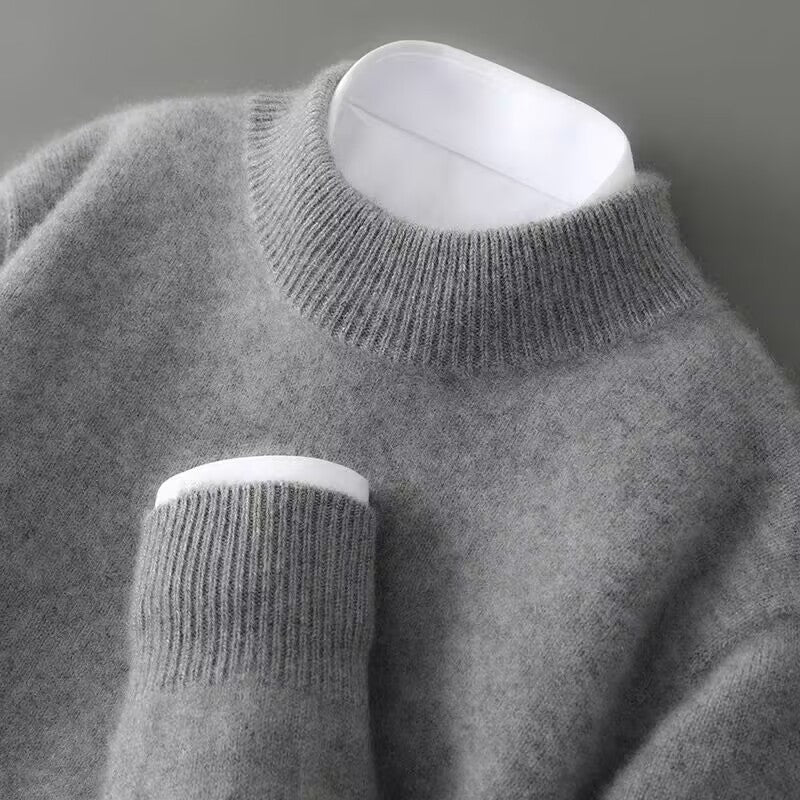 Close-up of the ribbed mock neck and cuff of a mid-grey knit jumper, layered over a crisp white shirt. 5
