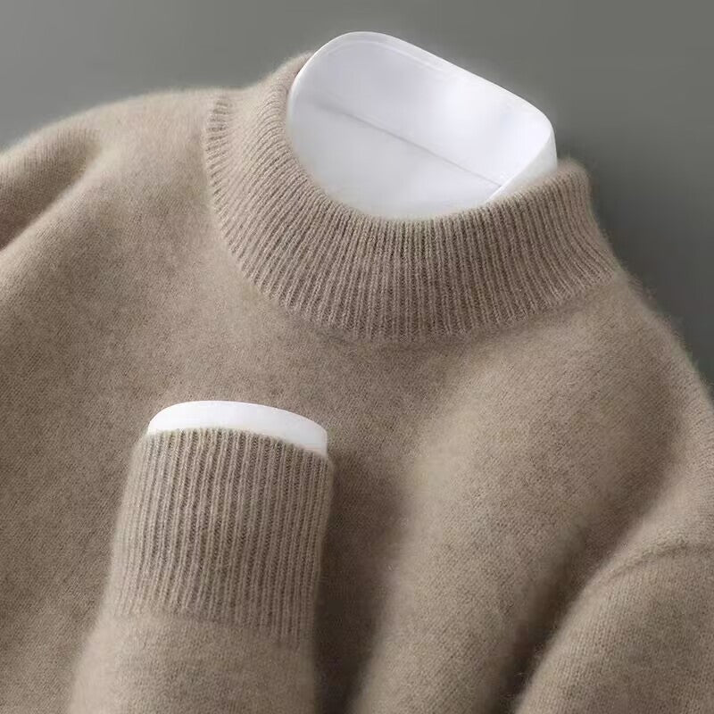 Close-up of the ribbed mock neck and cuff of a soft light brown knit jumper, layered over a white shirt. 2