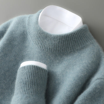 Close-up of the ribbed mock neck and cuff of a soft sage green knit jumper, worn over a white shirt. 4