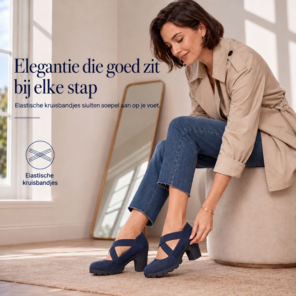 Smiling woman seated on a stool adjusting a navy crossed-strap block heel shoe in a bright room beside a mirror. 4