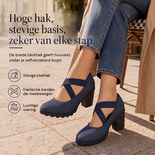 Navy shoes with crossed elastic straps worn by a seated woman in jeans and a trench coat on a paved street. 1