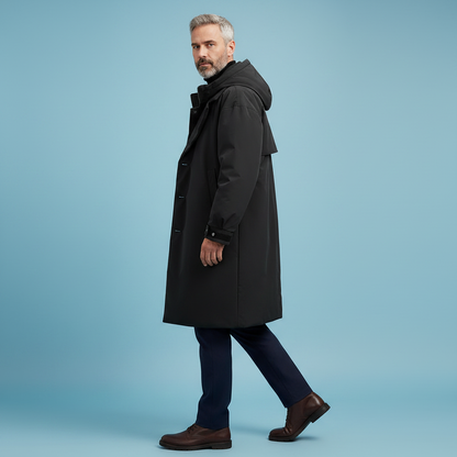 Side view of a model walking in the black hooded coat, showing sleeve length and buttons, with navy trousers and brown shoes. 6