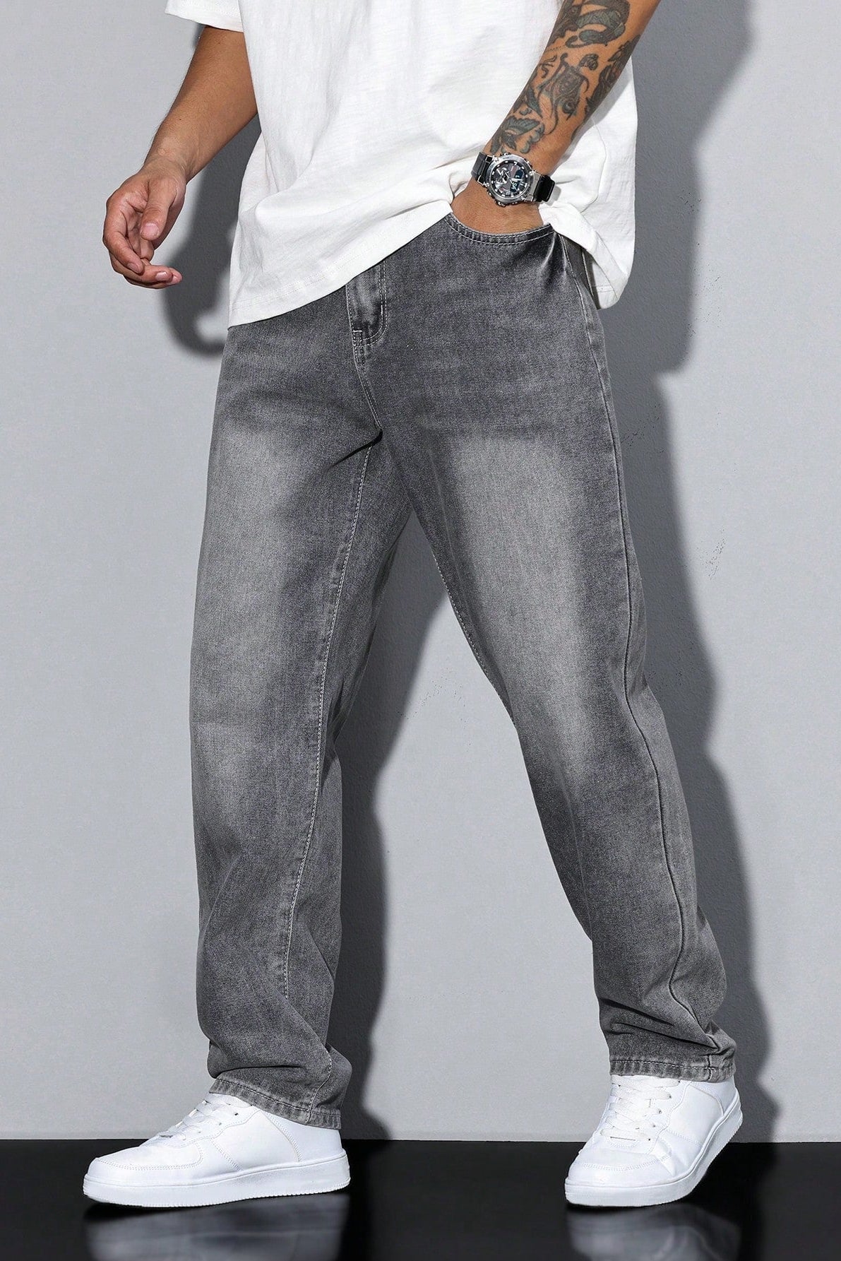 Side-angled view of a lighter grey washed pair worn with a white tee, watch and white trainers 5