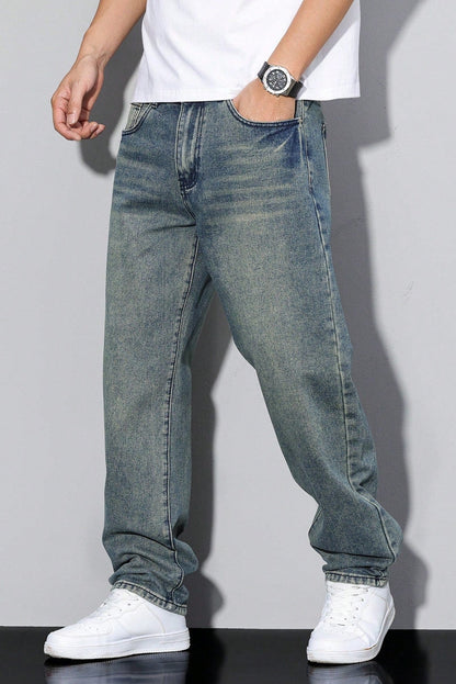 Model wearing the vintage-wash blue jeans with a greenish tint, hand in pocket, with white trainers 6