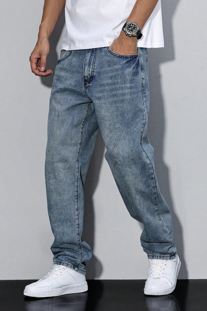 Model wearing a mid-blue acid-wash pair, one hand in the pocket, with a white tee and trainers 7