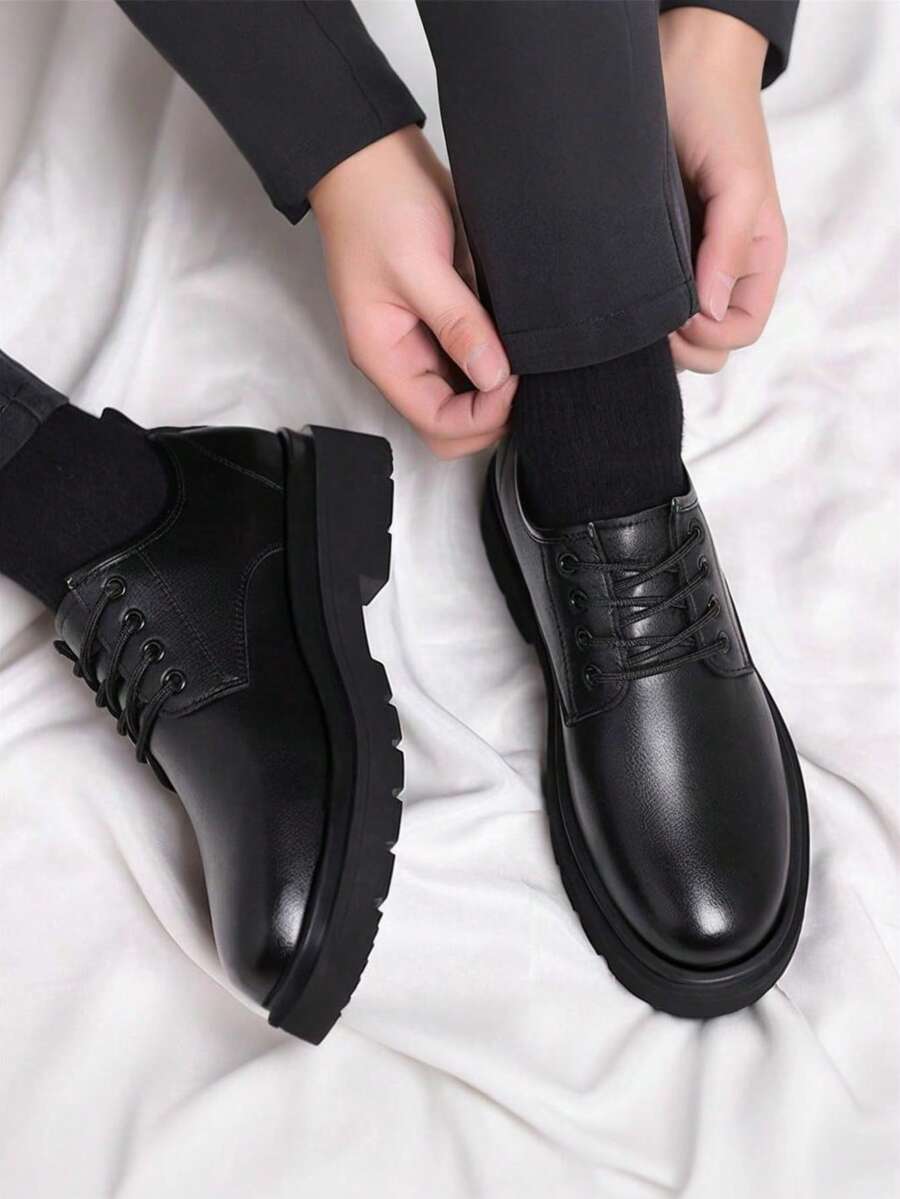 Model adjusting a trouser leg while seated, wearing the shoes with black socks, seen from above 3