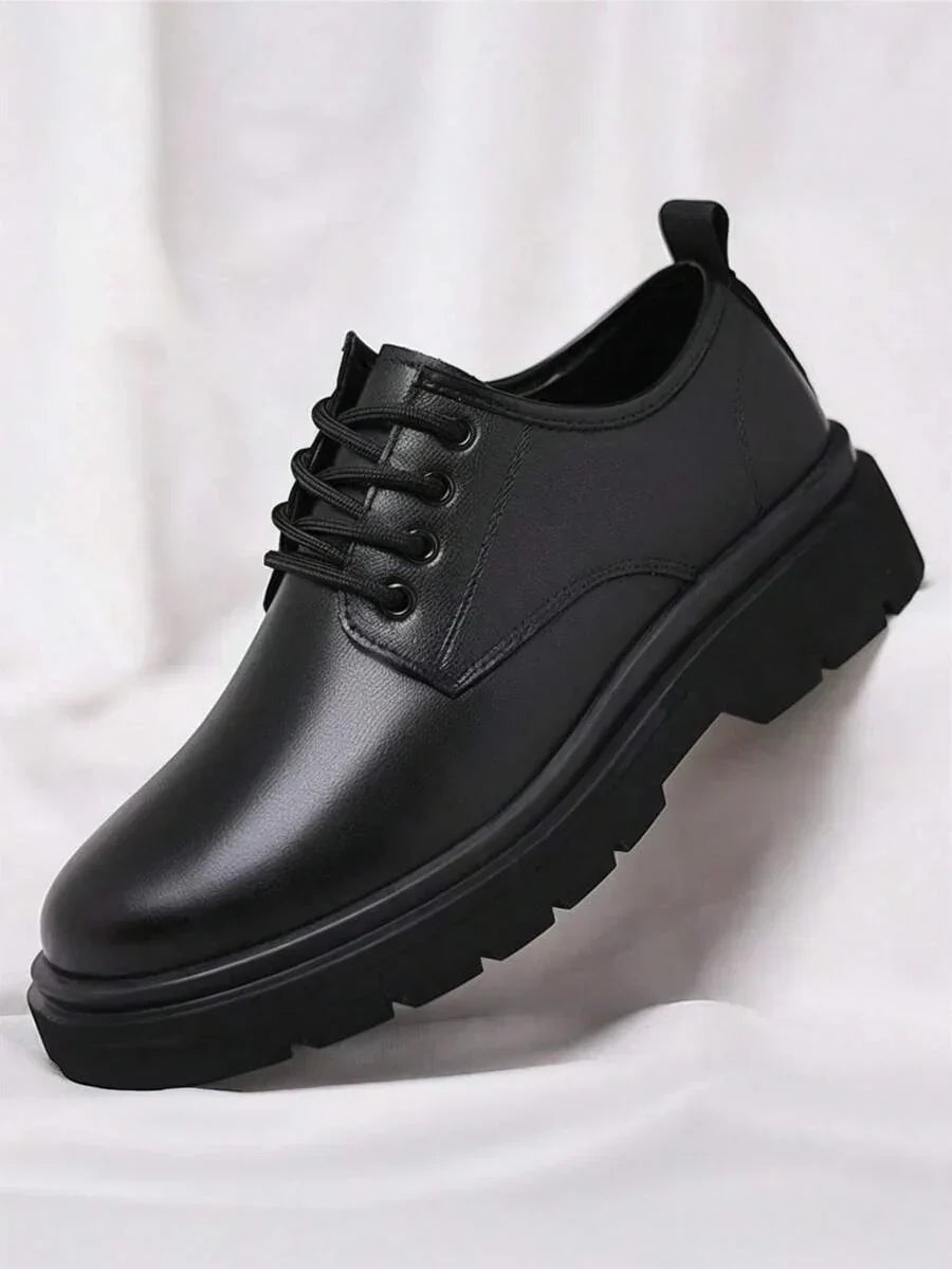 Single black derby shoe on its own against white fabric, showing the lacing and thick tread 5