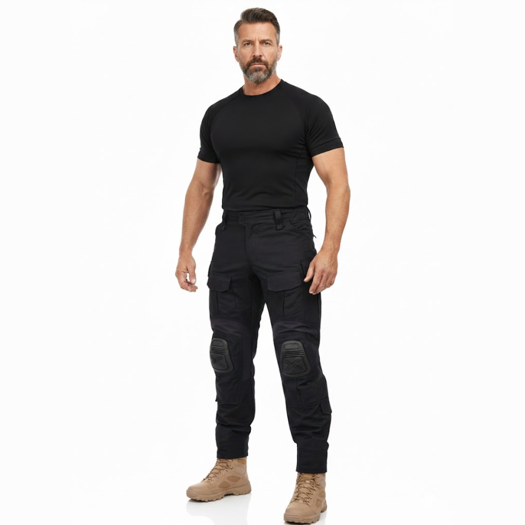 Bearded man in a black t-shirt and sand boots standing in the black trousers, full-length front view 7
