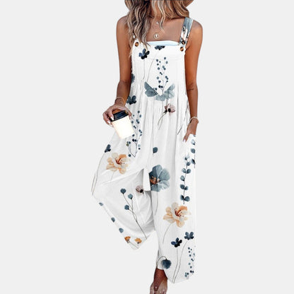 Model in white wide-leg dungarees with a delicate blue and peach floral print, holding a coffee cup 4
