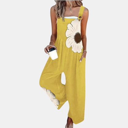 Model wearing yellow wide-leg dungarees with a large cream flower on the bib, front view 9