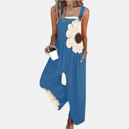 Model wearing blue wide-leg dungarees with a large cream flower on the bib, front view 6
