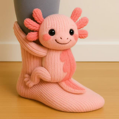Salmon-pink sock with a smiling axolotl figure with coral gills, angled view on a wooden floor 16
