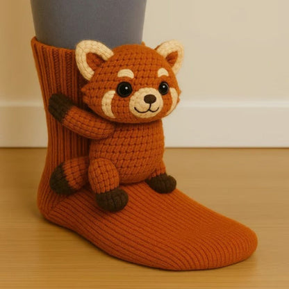 Rust-orange ribbed sock with a crocheted red panda figure perched on the ankle 5