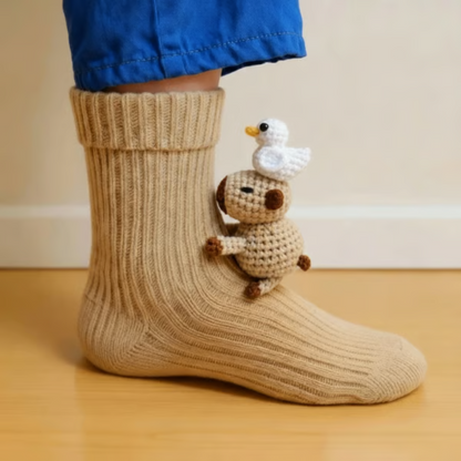 Beige ribbed sock with a tiny crocheted capybara carrying a white duck on its head 9