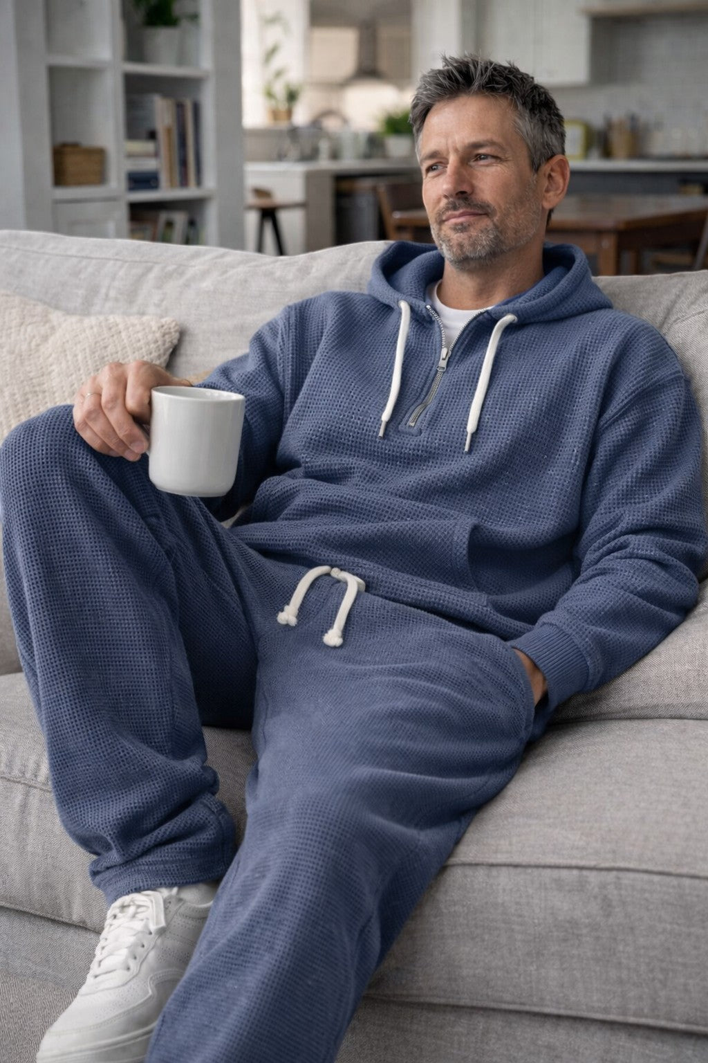 Man in the blue waffle-knit set relaxing on a sofa with a white mug 4
