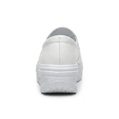 White slip-on shoe seen from behind, showing the heel stitching and curved wedge sole 18