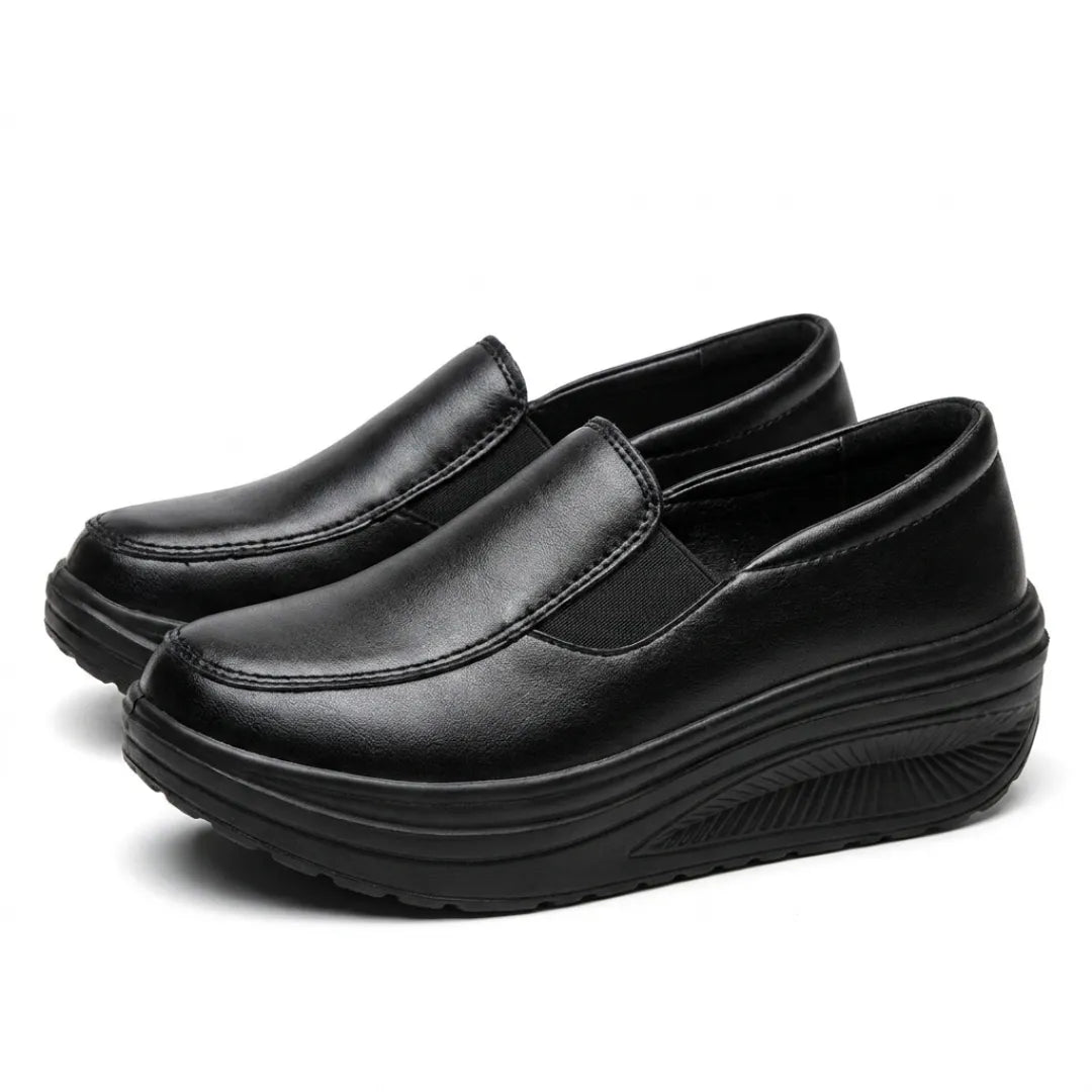 Pair of black slip-on wedge shoes angled from the front, with stitched toe seam and elastic gusset 7