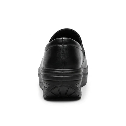 Black slip-on shoe seen from behind, showing the heel stitching and curved wedge sole 9