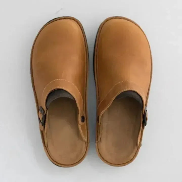 Overhead view of tan suede-look mule clogs with a side buckle and contrast stitching, showing the soft insole. 4
