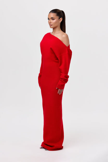 Side view of the red knit maxi dress, showing the asymmetric bare-shoulder neckline and gathered cuffs on the long sleeves. 22