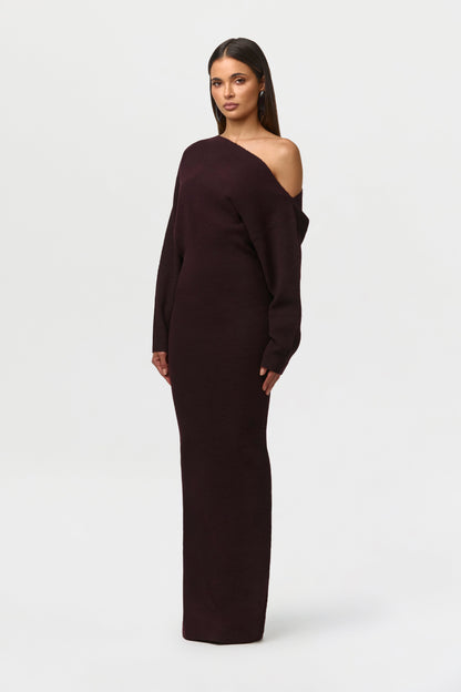 Angled side view of the deep burgundy-brown knit maxi dress, showing the asymmetric neckline and slim fit. 19