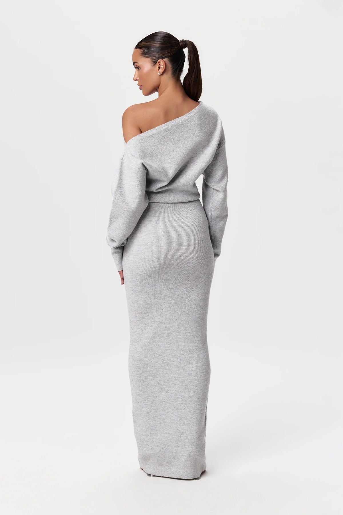 Back view of the light grey knit maxi dress, showing the bare shoulder and fitted skirt. 11