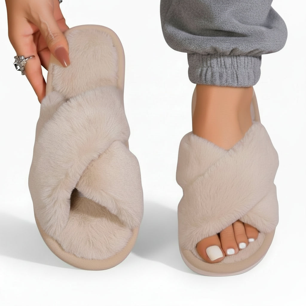 Cream fluffy crossover slippers, one worn with grey cuffed joggers and one held up by hand 7