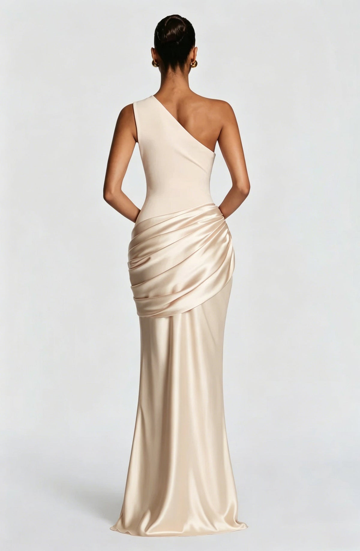 Back view of the cream one-shoulder maxi dress, showing the smooth asymmetric back and the glossy satin drape at the hip. 29