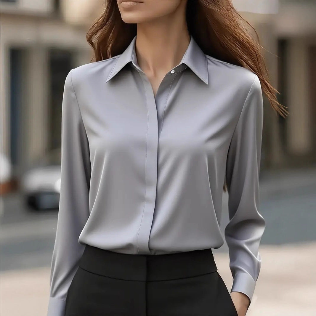 Model outdoors wearing the long-sleeved blouse in light grey with black trousers, hand in pocket 2