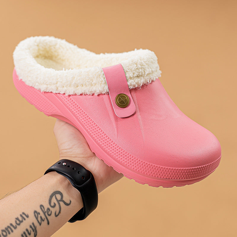 Hand holding a pink clog with cream fleece lining and a buttoned strap 16