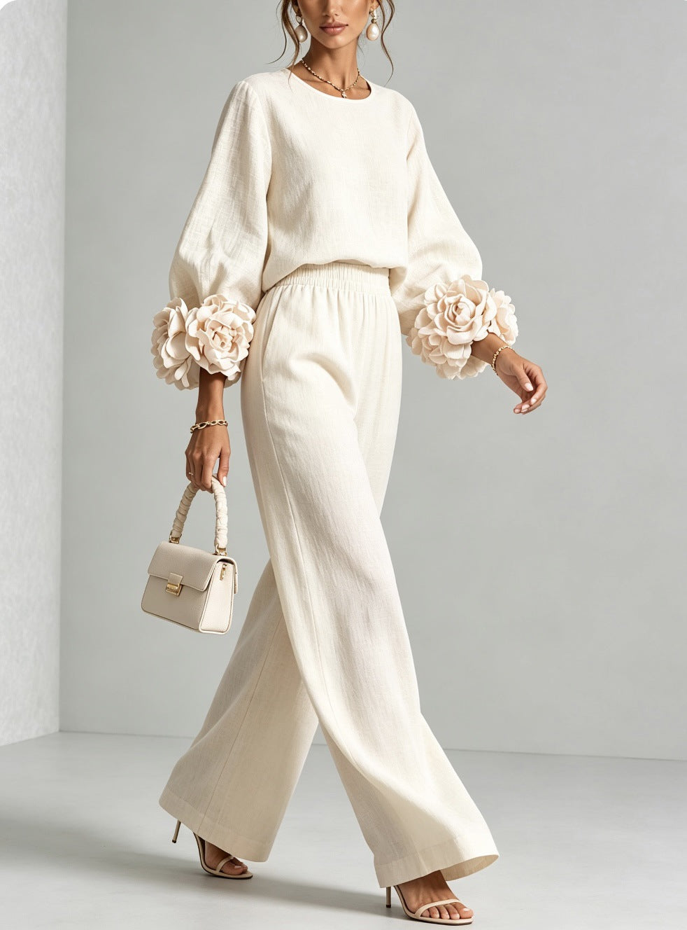 Model walking in the cream version, side-on, showing the flowing wide-leg trousers and large cuff flowers 4