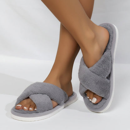Grey plush crossover slippers worn by a model, one foot turned to show the white sole 5