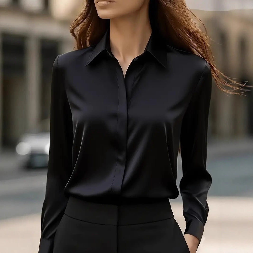 Model on a city street wearing the long-sleeved blouse in black with black trousers 1