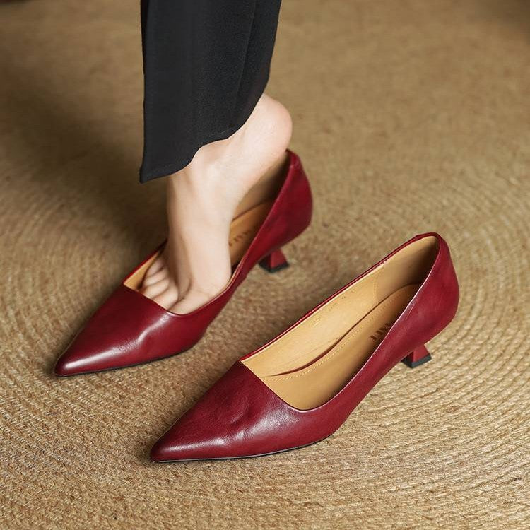 Red leather pumps with black trousers, one worn and one resting on the floor, showing the tan lining 8