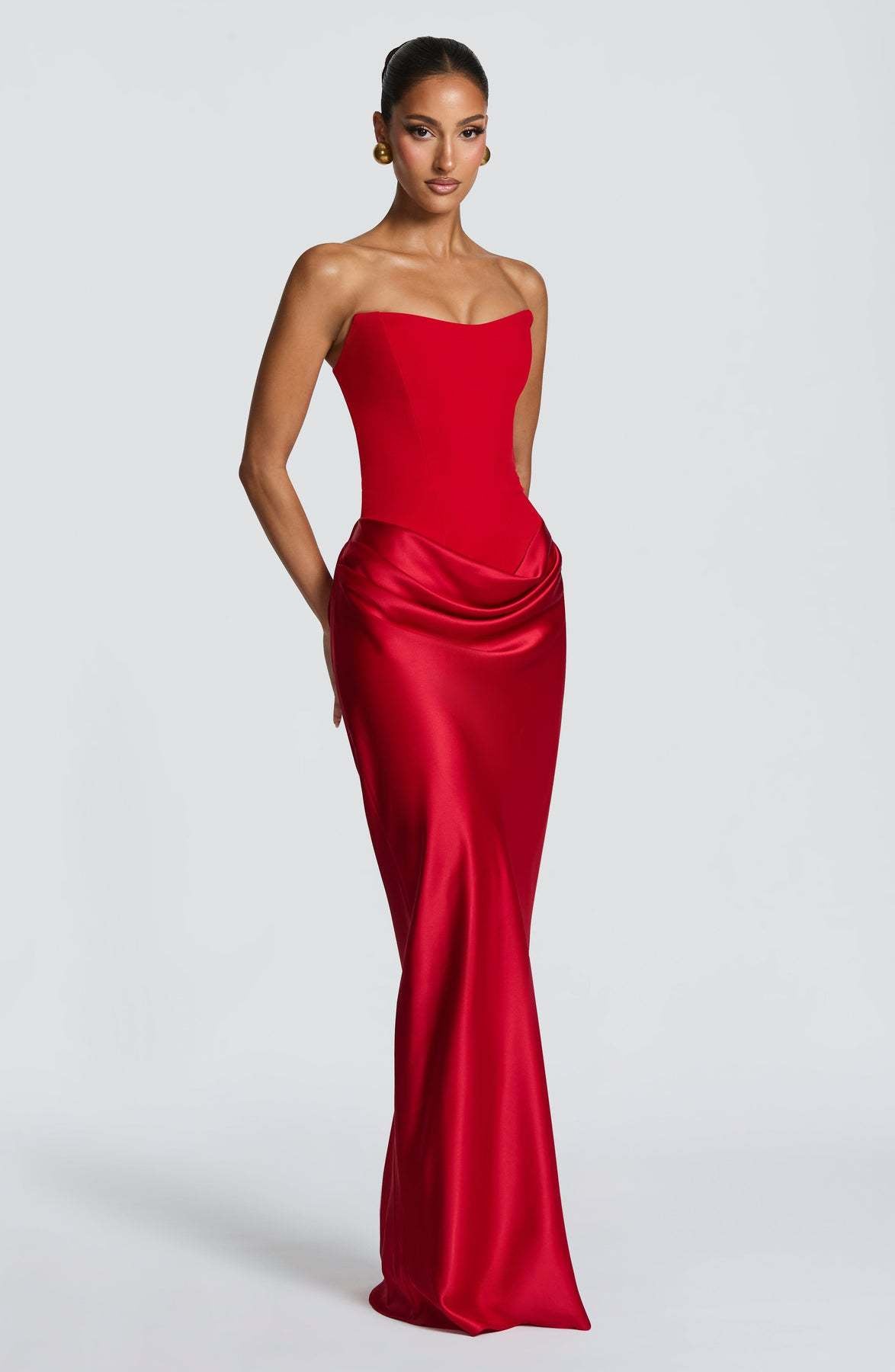 Red strapless corset maxi dress shown at an angle, highlighting the glossy satin skirt and hip drape 30