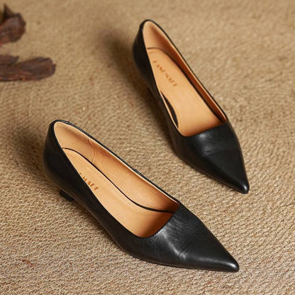 Pair of black leather pumps on woven matting, showing the tan lining and pointed toes 16