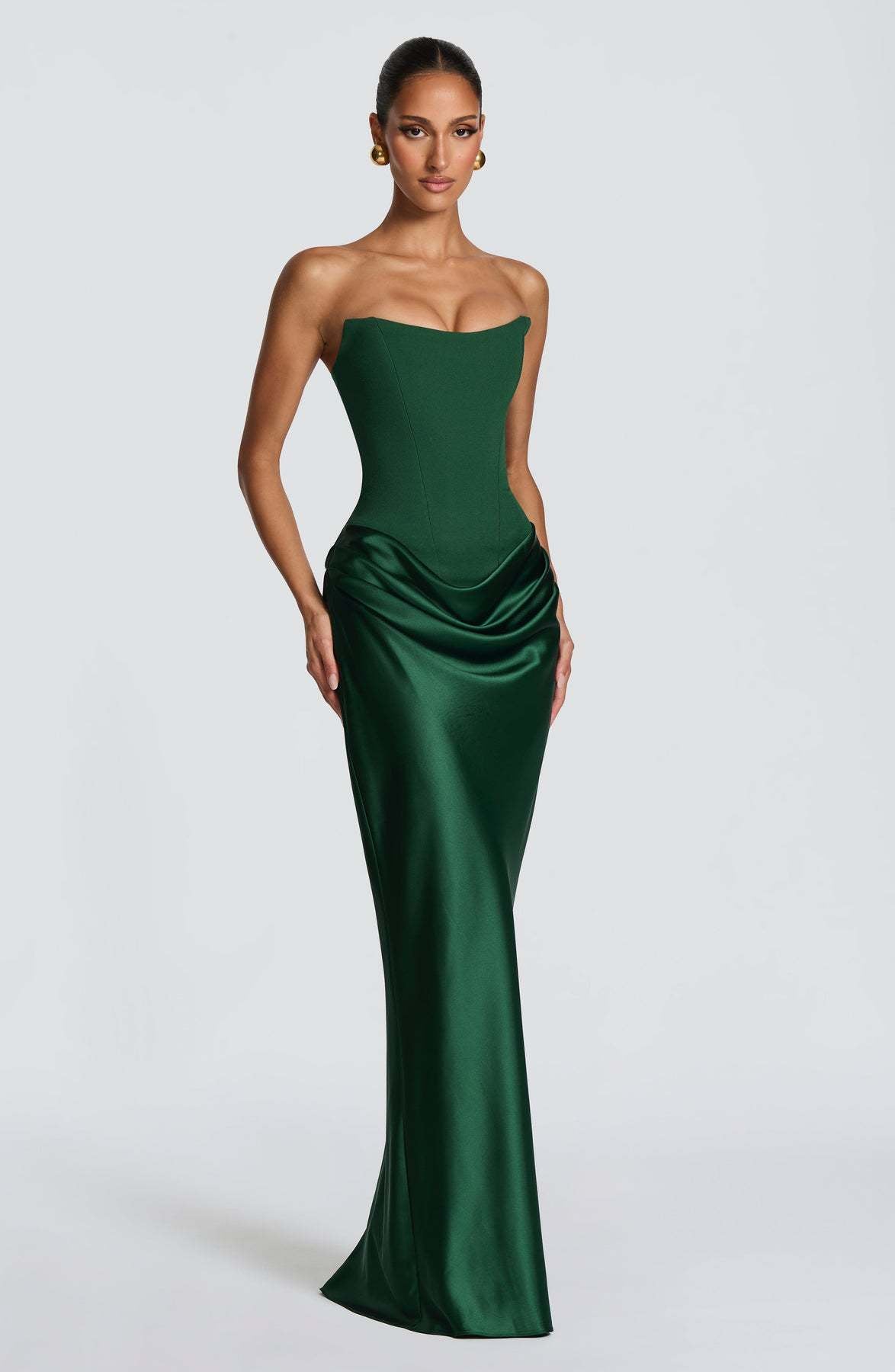 Emerald green strapless corset gown with draped hip satin skirt, shown at a three-quarter front angle 2