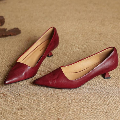 Pair of red leather pumps on woven matting, showing the tan lining and flared heels 11