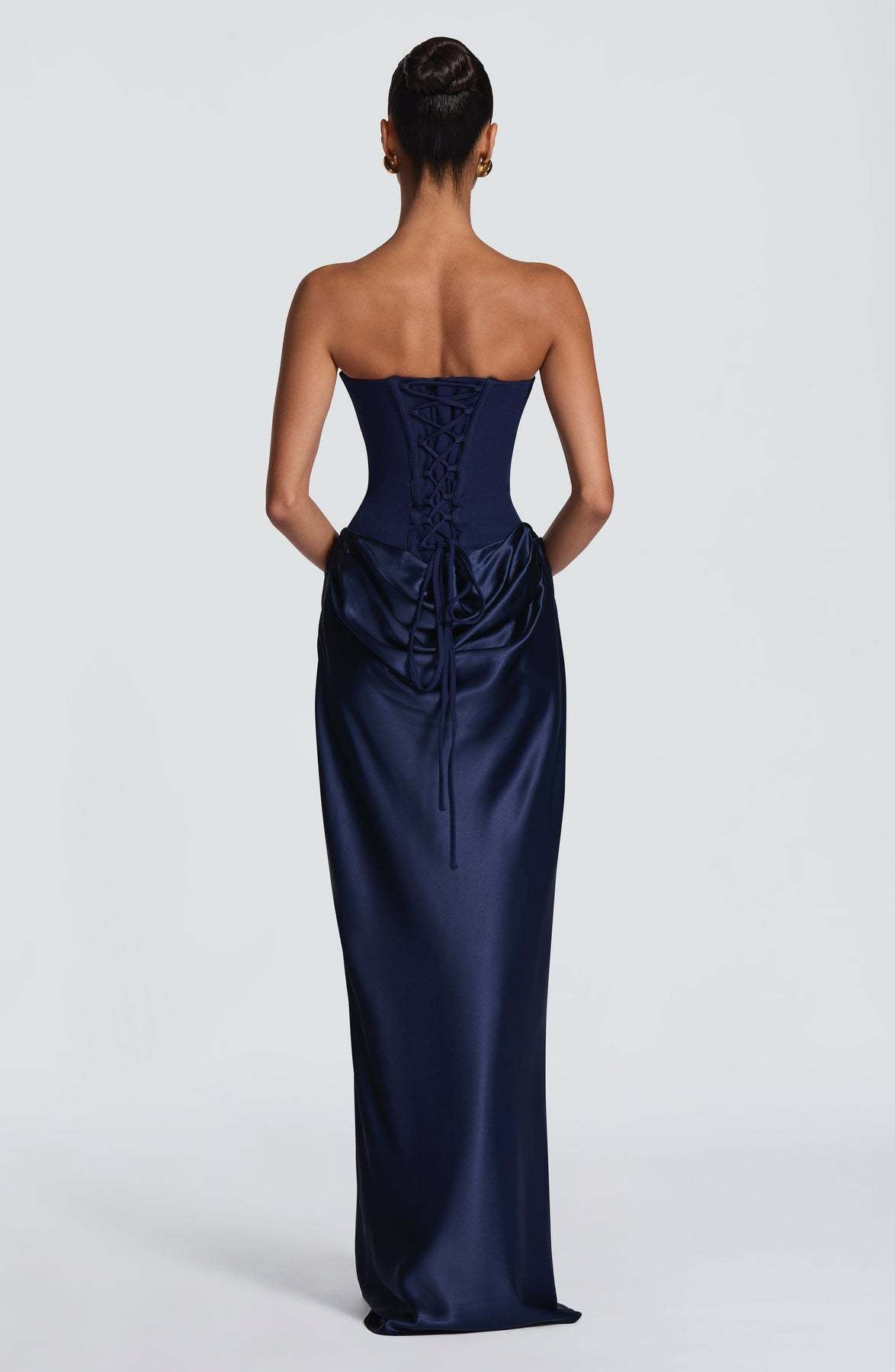Back of navy corset gown showing lace-up corset back with ties falling over draped satin 7