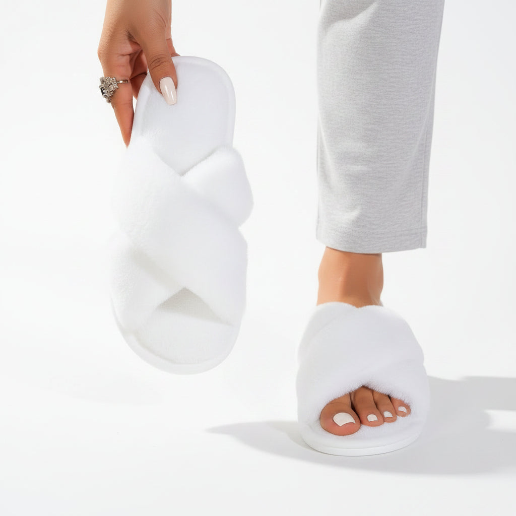 White fluffy crossover slippers, one worn with grey trousers and one held up to show the insole 6