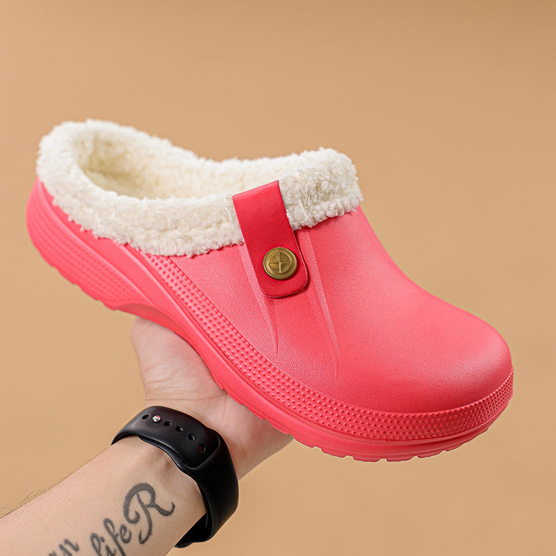 Hand holding a bright coral-red clog with cream fleece lining and a buttoned strap 17