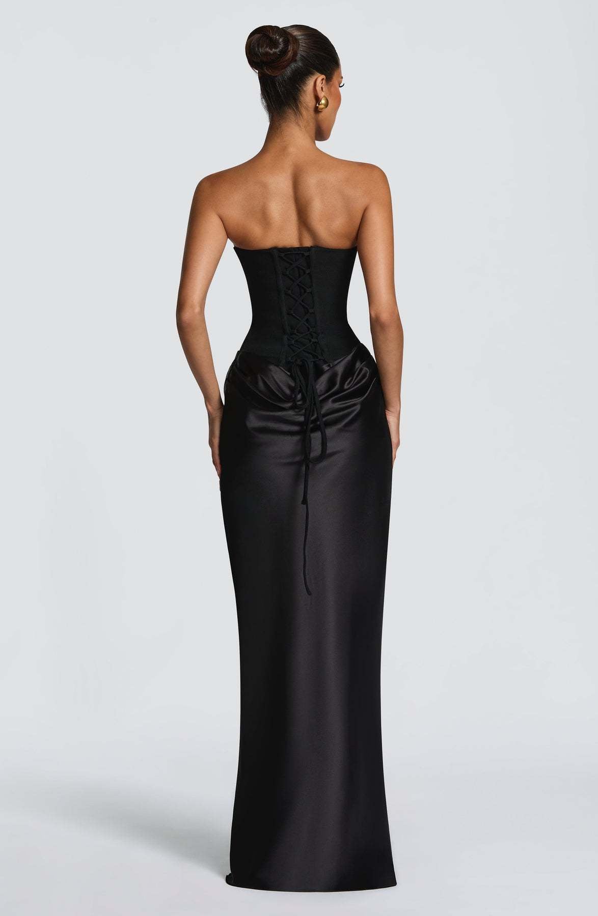 Back view of the black dress showing the lace-up corset back and trailing ties over satin 23