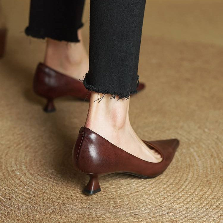 Rear view of brown leather kitten heels worn with black frayed trousers, showing the heel and back seam 20
