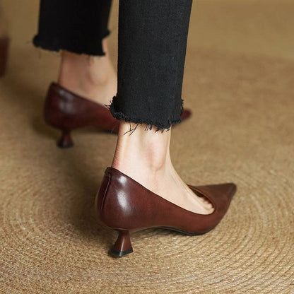 Rear view of brown leather kitten heels worn with black frayed trousers, showing the heel and back seam 20