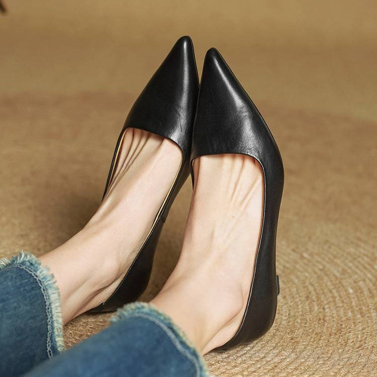 Close view of black pointed-toe pumps on feet, showing the low-cut front opening 15