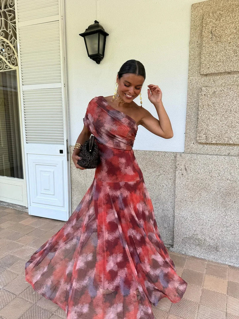 Model twirling in red and purple tie-dye mesh maxi dress, one shoulder bare, skirt swirling 2