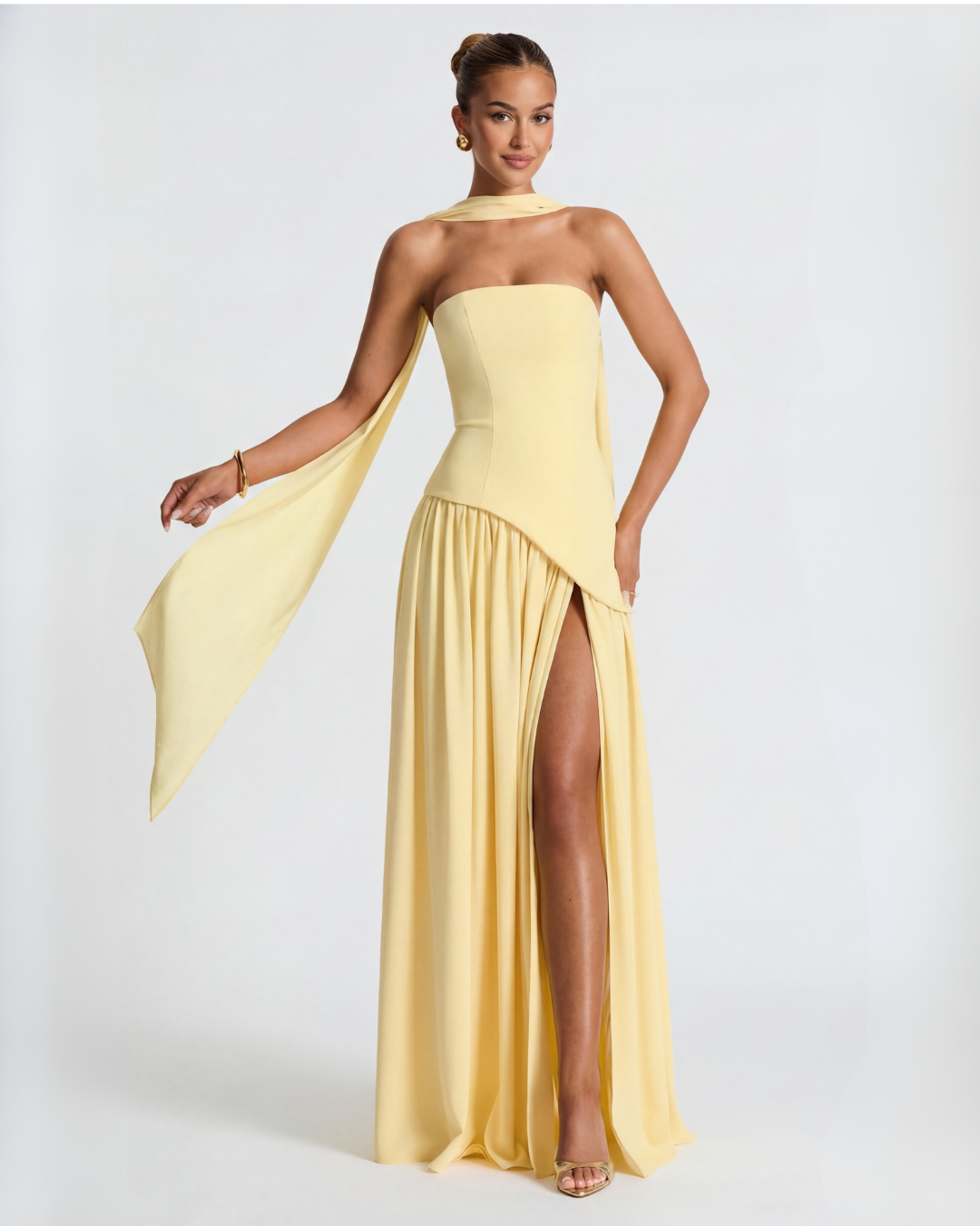 Pale yellow maxi dress with scarf flowing from the neck, held out to one side by the model 6