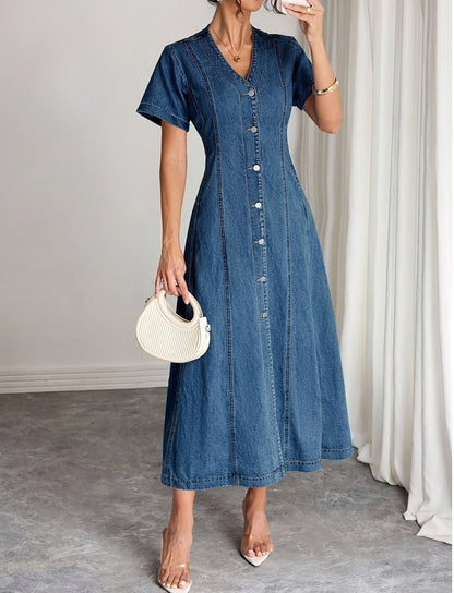 Model in the button-front denim midi dress holding a cream ribbed handbag, one hand raised 1