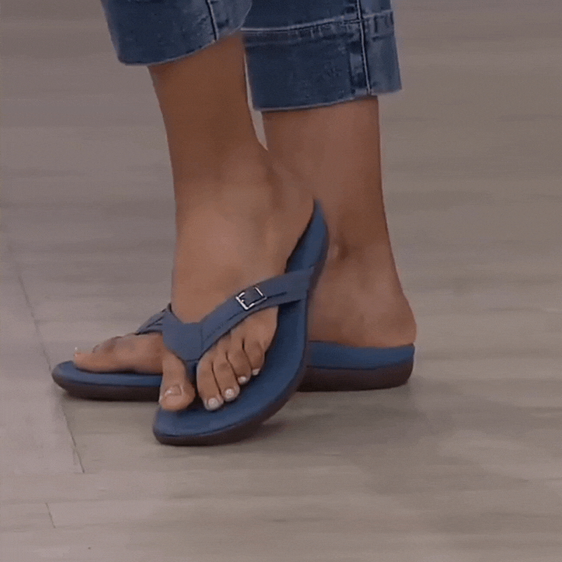 Woman in cuffed jeans wearing blue thong sandals with a small buckle on the strap 14
