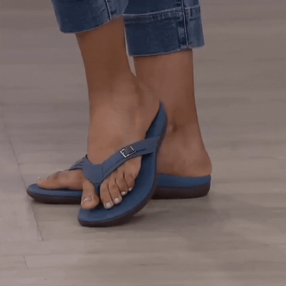 Woman in cuffed jeans wearing blue thong sandals with a small buckle on the strap 14